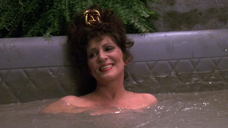 Lwaxana Troi (Majel Barrett) sits smiling in a mud bath in Star Trek: The Next Generation