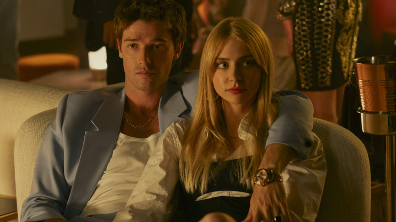 Golden Boy with one arm draped over Cate's shoulder