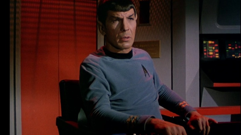 Mr. Spock from "Star Trek" sitting in the captain's chair on the Enterprise bridge