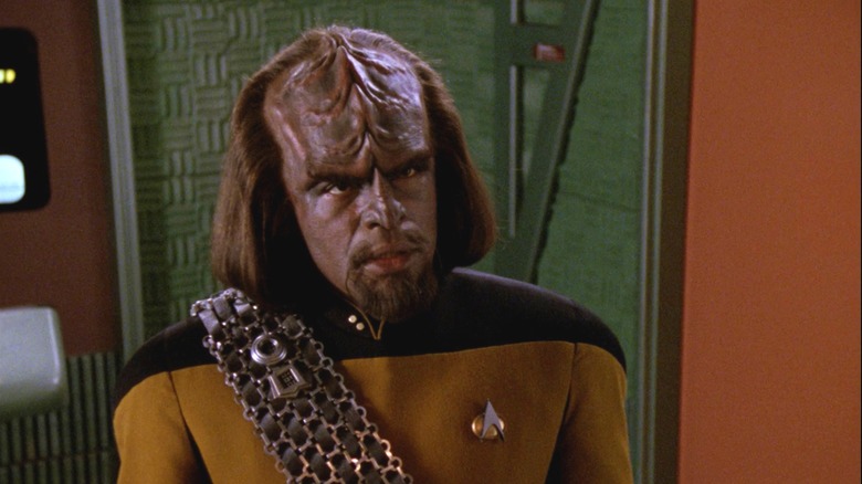 Worf talking to someone while wearing his Enterprise uniform and Baldric sash