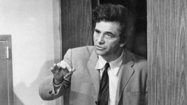Detective Columbo talking to someone off screen while holding a cigar