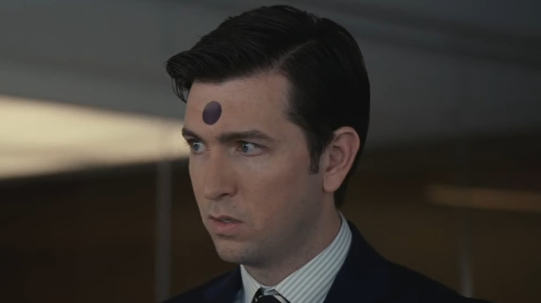 Nicholas Braun as Greg Hirsch, appearing confused with a purple sticker on his forehead on Succession