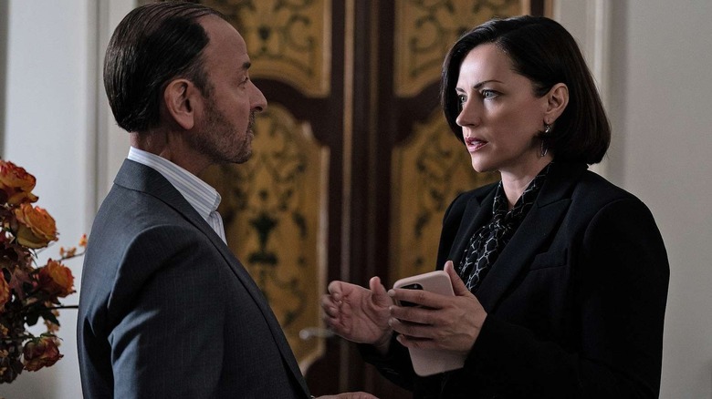 Fisher Stevens and Dagmara Dominczyk as Hugo Baker and Karolina Novotney, arguing near flowers on Succession