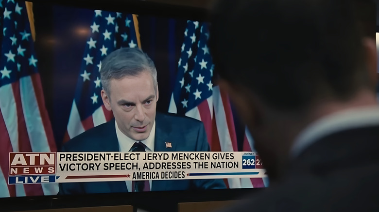 Justin Kirk as Jeryd Mencken, seen on a television screen giving a victory speech as Kendall watches on Succession