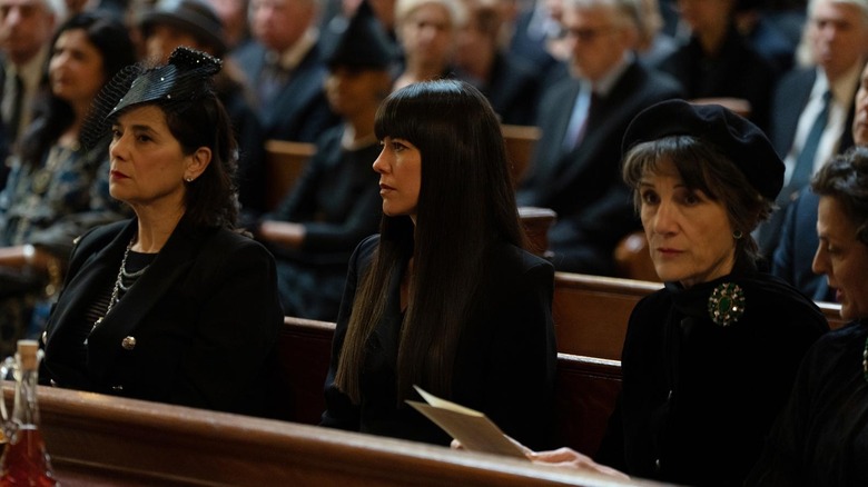 Zoe Winters as Kerry Castebellabate, sitting between Marcia and Caroline at Logan's funeral on Succession