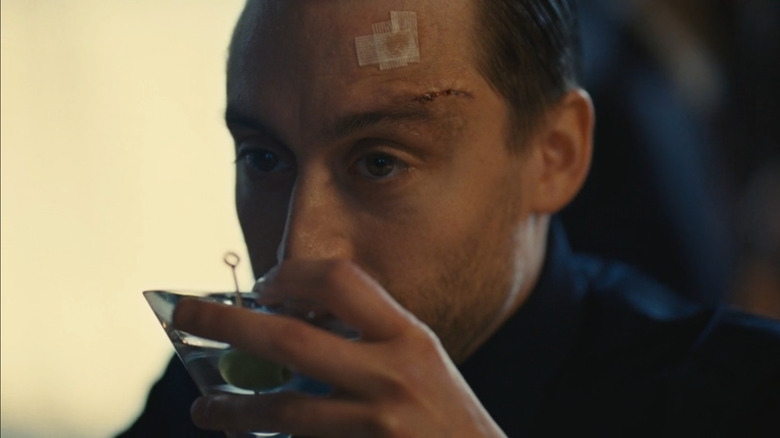 Kieran Culkin as Roman Roy, bandaged, bloodied, and sipping a martini on Succession