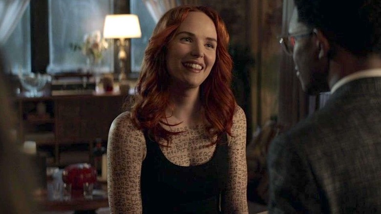 Stephanie Brown in a black tank top smiling and facing Luke Fox in Batwoman