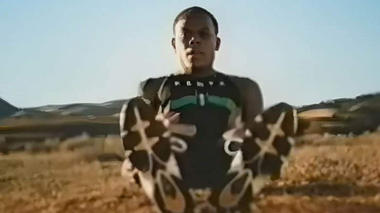 A kenyan professional runner looks down at sneakers.