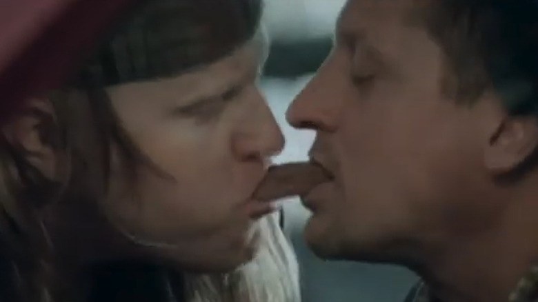 Two mechanics eat opposite ends of a snickers bar at the same time.