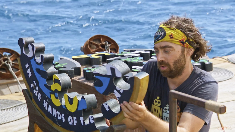 Christian Hubicki works on a puzzle in Survivor 50
