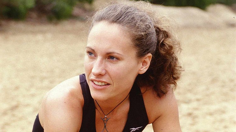 Jerri Manthey looking at someone sitting on the beach on Survivor