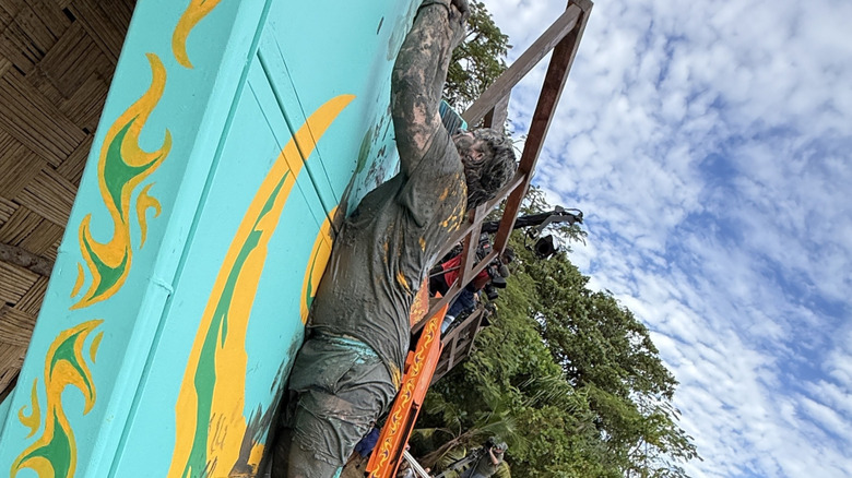 Nick Caruso climbs up the wall from the Survivor 50 premiere challenge