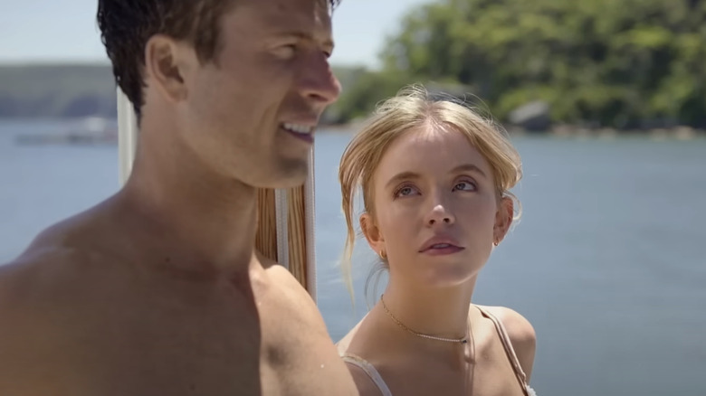 Sydney Sweeney's Bea Messina squints at Glen Powell's Ben as they stand on a boat in Anyone but You