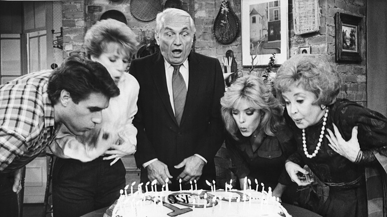 Ted Knight and the cast of Too Close for Comfort blowing out candles on a cake