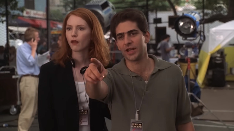 Alicia Witt and Michael Imperioli as Amy Safir and Christopher Moltisanti walking together toward a film set on The Sopranos