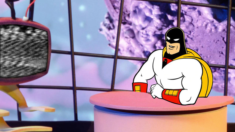 Space Ghost (George Lowe) sits smiling at his desk in Space Ghost Coast to Coast