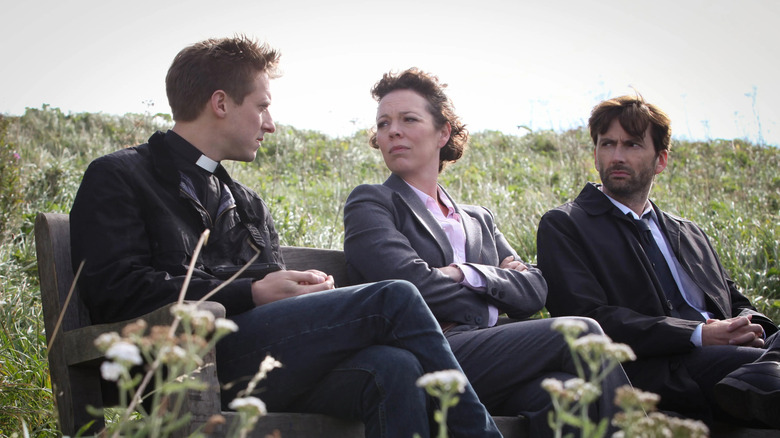 Paul Coates (Arthur Darvill) speaks with Ellie Miller (Olivia Colman) and Alec Hardy (David Tennant) on a park bench on Broadchurch