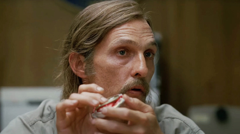 Rust Cohle (Matthew McConaughey) holds a crumpled beer can on True Detective
