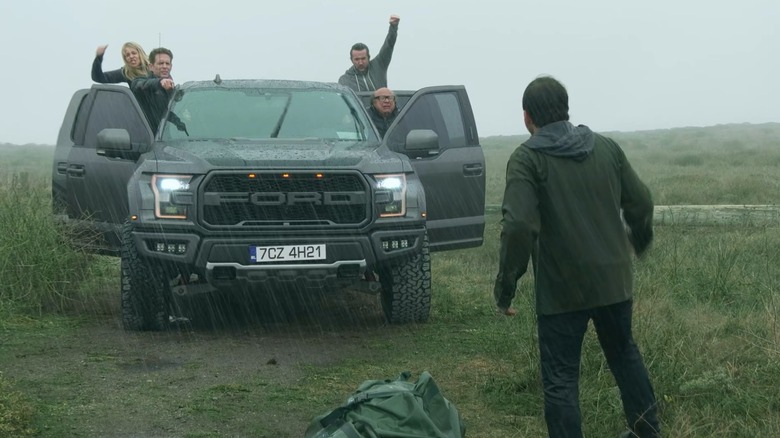 Kaitlin Olson, Glenn Howerton, Rob Mac, and Danny DeVito as Dee, Dennis, Mac, and Frank in a Ford truck facing Charlie Day as Charlie in the rain on Always Sunny