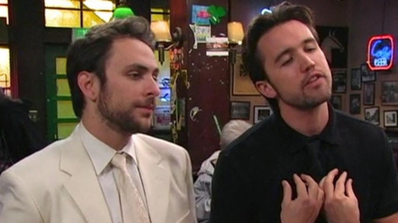 Charlie Day as Charlie wearing a white suit with Rob Mac as Mac wearing a black shirt on Always Sunny