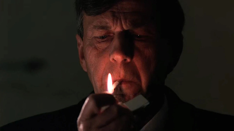 William B. Davis as the Cigarette Smoking Man lighting cigarette in the dark in The X-Files