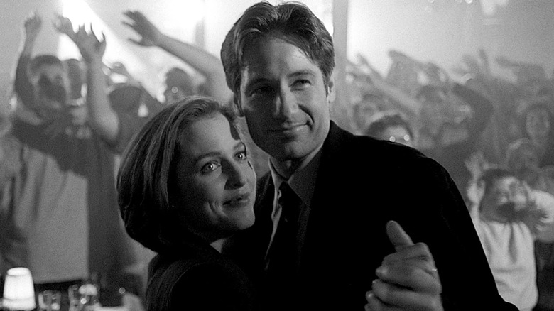 Gillian Anderson as Scully and David Duchovny as Mulder dancing in bar in black and white in The X-Files