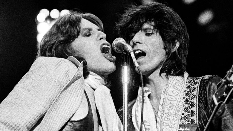 Mick Jagger and Keith Richards sing into microphone on stage in Crossfire Hurricane