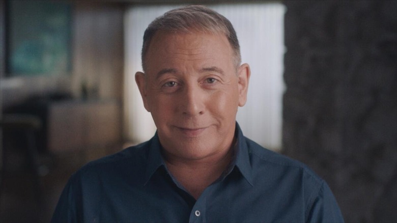 An older Paul Reubens smiles slightly at the camera in Pee-wee Herman as Himself