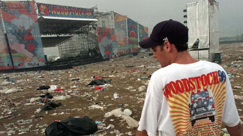 A fan stands by a trashed Woodstock 99 stage in Woodstock 99: Peace, Love, and Rage