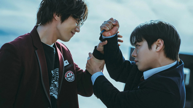 Geum Seong-je (Lee Jun-young) smirks while stopping Yeon Si-eun (Park Ji-hoon) from stabbing him with a pen on Weak Hero