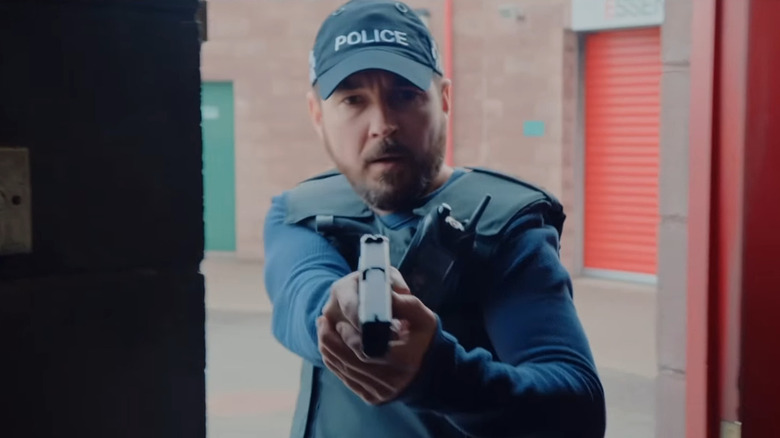 Martin Compston as Steve Arnott, entering a storage container with a gun drawn on Line of Duty