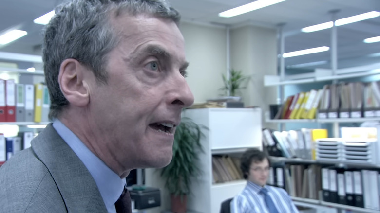 Peter Capaldi as Malcom Tucker, screaming over Ollie's desk in The Thick of It