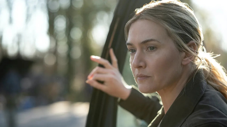 Mare Sheehan (Kate Winslet) exits her car on the road on Mare of Easttown