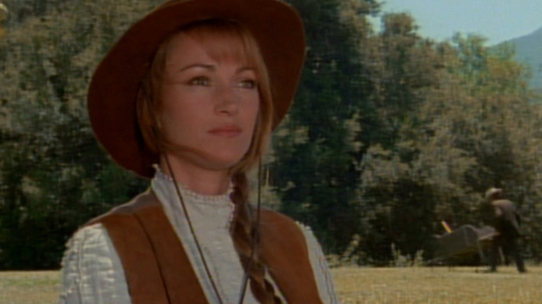 Michael Quinn (Jane Seymour) stands outside near a forest in Dr. Quinn, Medicine Woman