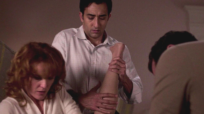 Keri Russell as Elizabeth Jennings and Rahul Khanna as Yousaf play with body parts on The Americans