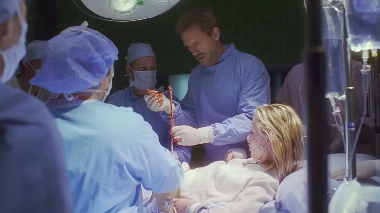Hugh Laurie as House extracts a worm from a patient on House M.D.