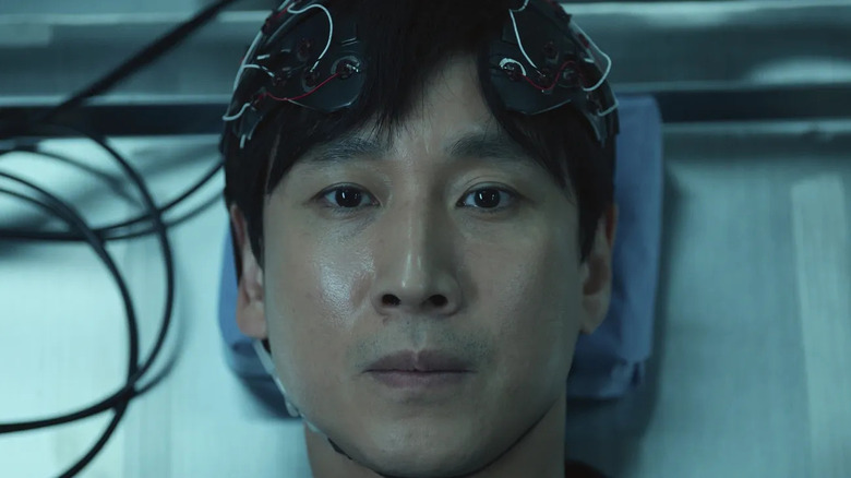 Sewon Koh stares up grimly while wearing brain monitors in Dr. Brain