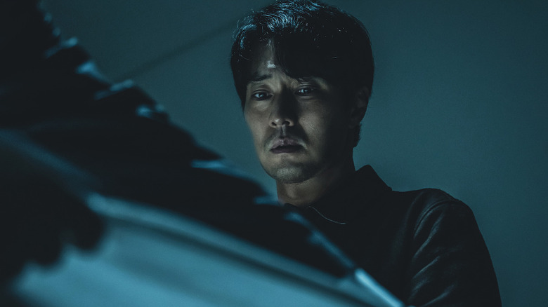 Nam Gi-jun looking solemnly at a body bag in Mercy for None