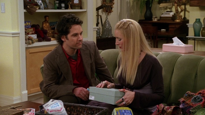 Paul Rudd and Lisa Kudrow as Mike and Phoebe, sitting on a couch holding a shoe box in Friends