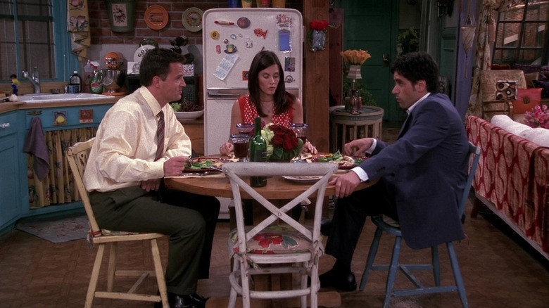 Chandler (Matthew Perry), Monica (Courteney Cox), and Zack (John Stamos) sit around a dinner table in Friends