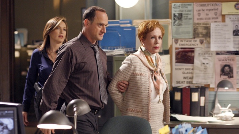 Elliot Stabler (Christopher Meloni) escorting a handcuffed Birdie (Carol Burnett) through the squad room on Law & Order: Special Victims Unit