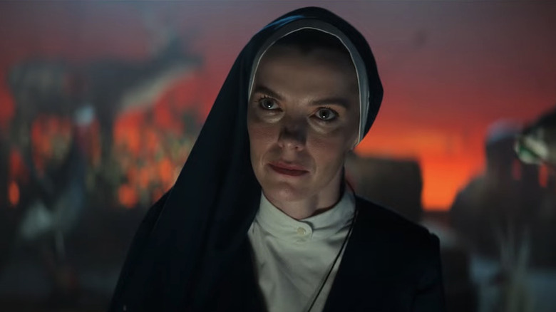 Sister Simone (Betty Gilpin) smirks in a club in Mrs. Davis