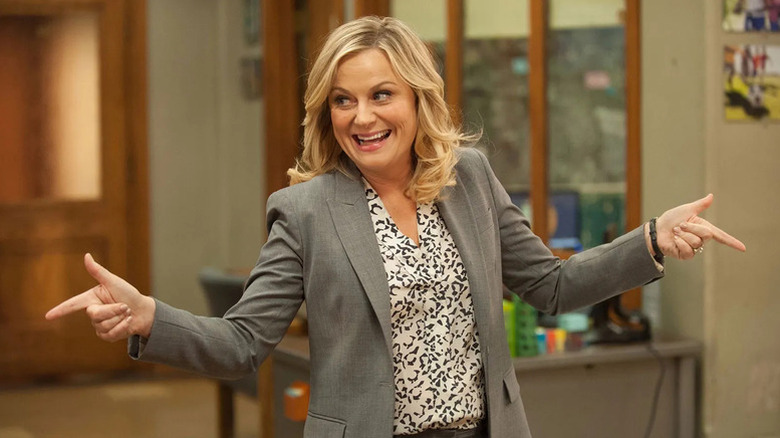 Leslie Knope (Amy Poehler) points finger guns while smiling in Parks and Recreation