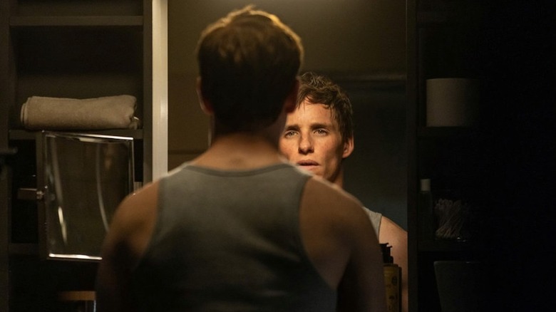 The Jackal (Eddie Redmayne) looking in the mirror in The Day of the Jackal