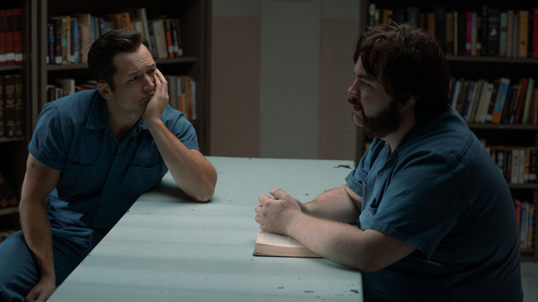 Jimmy Keene (Taron Egerton) listens to Larry Hall (Paul Walter Hauser) speak in a prison library on Black Bird