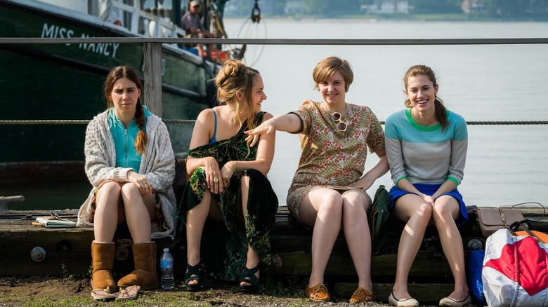 Shoshanna (Zosia Mamet), Jessa (Jemima Kirke), Hannah (Lena Dunham), and Marnie (Allison Williams) sitting at a dock on Girls
