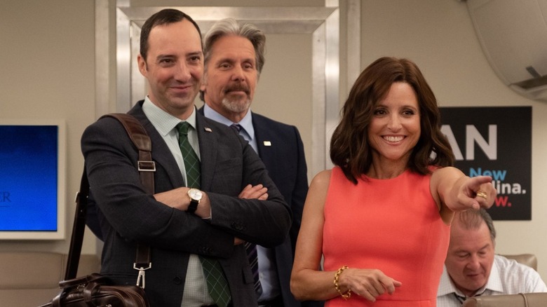 Selina (Julia Louis-Dreyfus) pointing next to Gary (Tony Hale) with Kent (Gary Cole) and Ben (Kevin Dunn) in the background on her plane on Veep