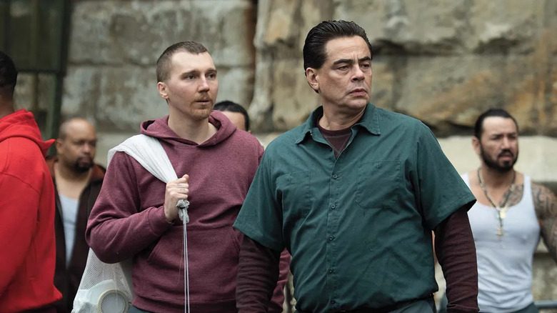 Paul Dano and Benicio del Toro as David Sweat and Richard Matt, standing next to each other in the prison yard in Escape at Dannemora