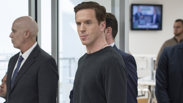 Damien Lewis as Bobby Axelrod, surrounded by men in suits on Billions