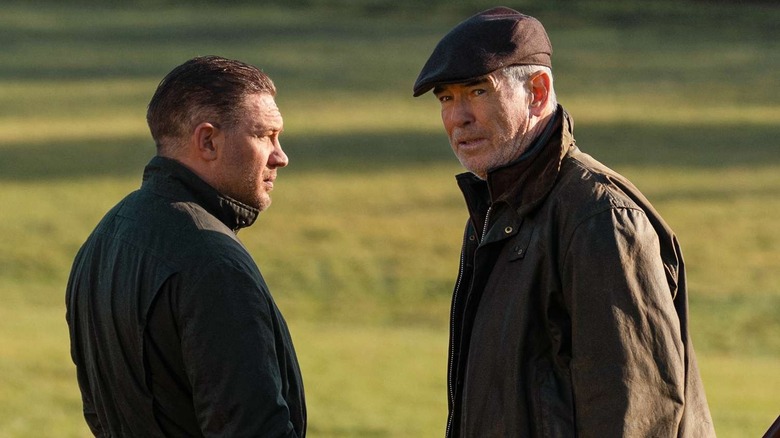 Tom Hardy and Pierce Brosnan as Harry Da Souza and Conrad Harrigan, standing by a lake on MobLand